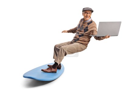 Téléchargez les photos : Homme âgé surfant avec une planche de surf et tenant un ordinateur portable isolé sur fond blanc - en image libre de droit