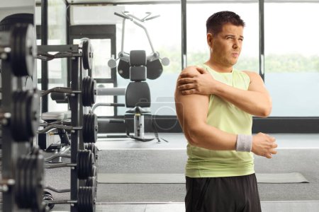 Hombre con hombro lesionado haciendo ejercicio en un gimnasio