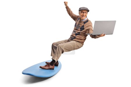 Téléchargez les photos : Homme âgé sur une planche de surf tenant un ordinateur portable isolé sur fond blanc - en image libre de droit
