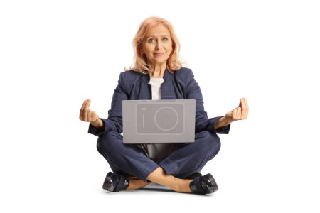 Photo for Businesswoman with a laptop computer sitting in a meditation pose isolated on white background - Royalty Free Image