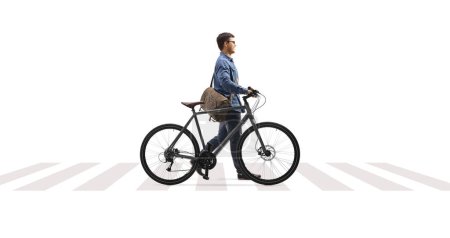 Photo for Full length profile shot of a man crossing a street and pushing a bicycle isolated on white background - Royalty Free Image