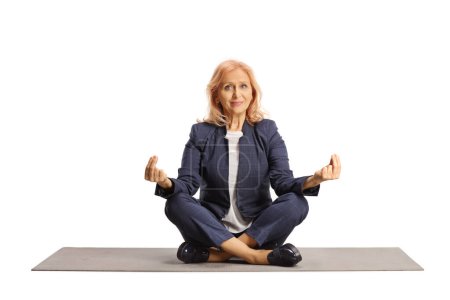 Photo for Businesswoman sitting on an exercise mat and meditating isolated on white background - Royalty Free Image
