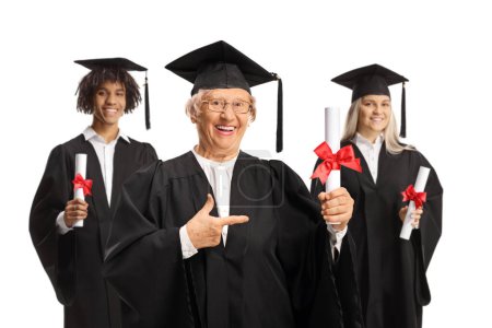 Photo for Graduation students and an elderly woman holding certificates and pointing isolated on white background - Royalty Free Image