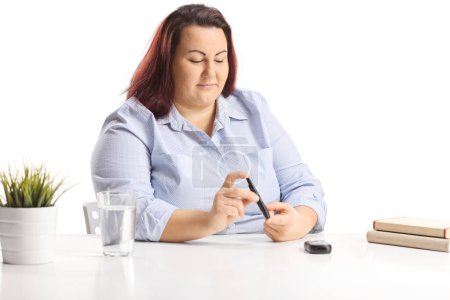 Corpulent jeune femme assise et poing doigt avec un stylo à insuline 
