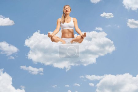 Foto de Mujer joven meditando en las nubes en el cielo azul - Imagen libre de derechos