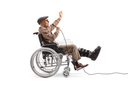 Foto de Hombre mayor alegre con un aparato ortopédico sentado en una silla de ruedas y cantando con un micrófono aislado sobre fondo blanco - Imagen libre de derechos
