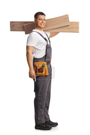 Téléchargez les photos : Plan complet d'un charpentier tenant des poutres en bois isolées sur fond blanc - en image libre de droit