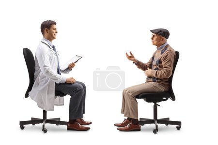 Téléchargez les photos : Homme âgé et un jeune médecin masculin assis et parlant isolé sur fond blanc - en image libre de droit