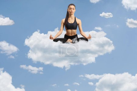 Photo for Young female practicing meditation on coud up in the sky - Royalty Free Image