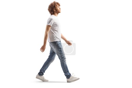 Photo for Full length profile shot of a casual guy with fair curly hair walking isolated on white background - Royalty Free Image