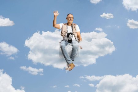 Photo for Photographer with a camera sitting on a cloud and waving - Royalty Free Image