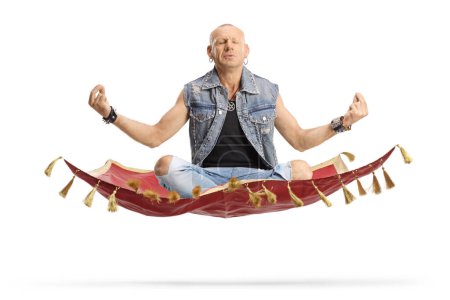 Photo for Bald man sitting corssed legged and practicing meditation on a magic carpet isolated on white background - Royalty Free Image