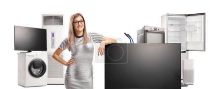 Mujer joven posando con pantalla plana de televisión y electrodomésticos aislados sobre fondo blanco