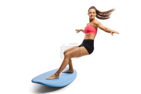 Téléchargez les photos : Femme surfeuse chevauchant une planche de surf isolée sur fond blanc - en image libre de droit