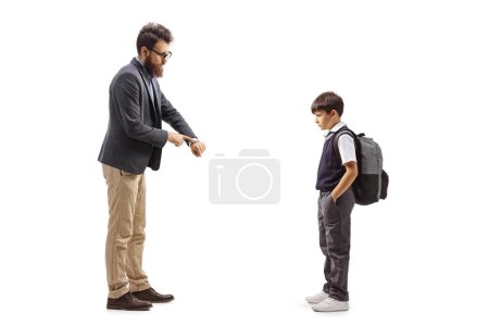 Photo for Full length profile shot of a man reprimanding a schoolboy and showing time on watch isolated on white background - Royalty Free Image