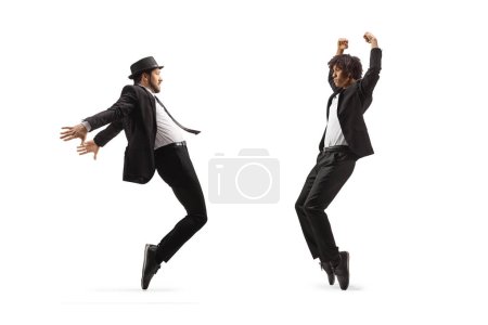 Full length shot of a male dancers in black suits dancing isolated on white background