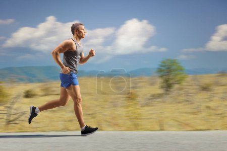 Foto de Ajuste joven corriendo en la naturaleza en un camino abierto - Imagen libre de derechos