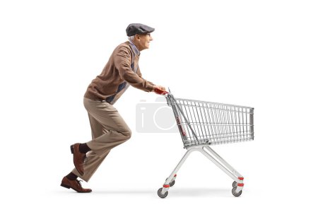 Photo for Full length profile shot of a senior pensioner running with an empty shopping cart isolated on white background - Royalty Free Image