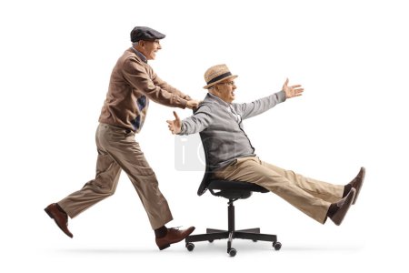 Téléchargez les photos : Homme âgé poussant un ami sur une chaise de bureau isolé sur fond blanc - en image libre de droit