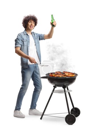 Photo for Happy young man holding a bottle of beer and making a bbq isolated on white background - Royalty Free Image