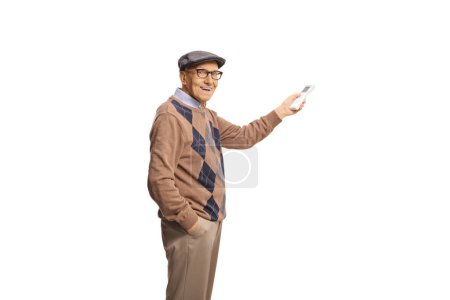 Foto de Feliz anciano sosteniendo un mando a distancia para la unidad de aire acondicionado aislado sobre fondo blanco - Imagen libre de derechos
