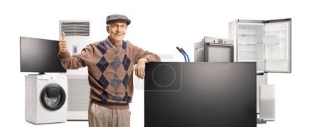Téléchargez les photos : Homme âgé dans un magasin d'appareils ménagers gesticulant pouces vers le haut isolé sur fond blanc - en image libre de droit