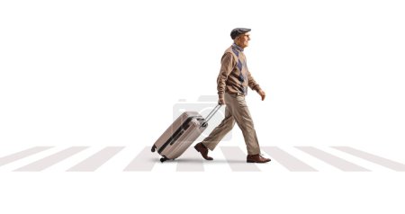 Téléchargez les photos : Photo de profil pleine longueur d'un homme âgé tirant une valise et marchant dans une rue isolée sur fond blanc - en image libre de droit