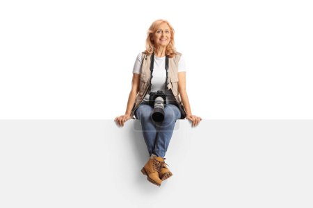 Foto de Mujer foto periodista sentada en un panel en blanco aislado sobre fondo blanco - Imagen libre de derechos
