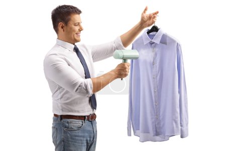 Téléchargez les photos : Homme utilisant un fer à vapeur pour une chemise isolée sur fond blanc - en image libre de droit