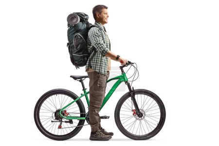 Photo for Full length profile shot of a man with a backpack standing with a bicycle isolated on white background - Royalty Free Image