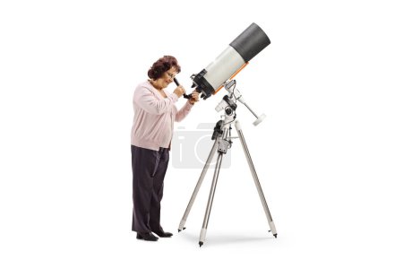 Photo for Full length shot of an elderly woman observing through a telescope isolated on white background - Royalty Free Image
