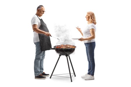 Téléchargez les photos : Femme parlant à un homme faisant un barbecue isolé sur fond blanc - en image libre de droit