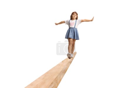 Téléchargez les photos : Fille marche sur une poutre en bois isolé sur fond blanc - en image libre de droit
