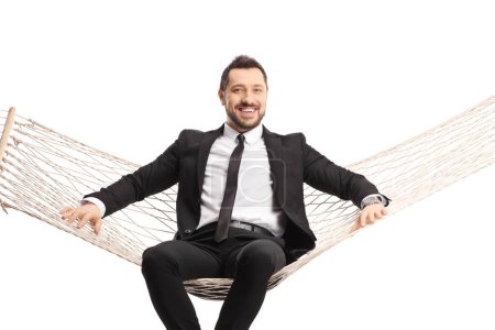 Téléchargez les photos : Homme d'affaires heureux assis sur une balançoire hamac isolé sur fond blanc - en image libre de droit