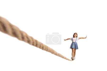 Téléchargez les photos : Enfant marchant sur une corde raide isolée sur fond blanc - en image libre de droit