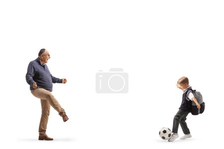 Foto de Hombre maduro jugando al fútbol con un colegial aislado sobre fondo blanco - Imagen libre de derechos