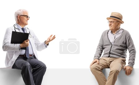 Téléchargez les photos : Médecin mature et un patient âgé assis sur un panneau et parlant isolé sur fond blanc - en image libre de droit