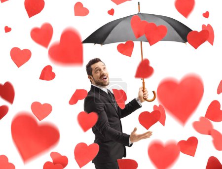 Téléchargez les photos : Homme avec parapluie sous la pluie de cœurs isolés sur fond blanc - en image libre de droit