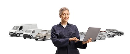 Téléchargez les photos : Travailleuse dans un uniforme bleu marine avec un ordinateur portable devant des camionnettes isolées sur fond blanc - en image libre de droit