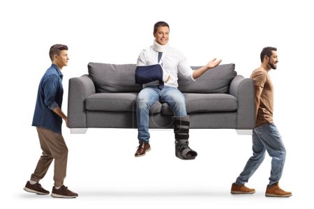 Photo for Young men carrying a gray sofa with an injured man isolated on white background - Royalty Free Image