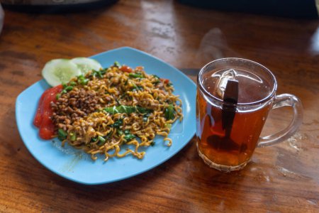 Téléchargez les photos : Nouille instantanée populaire indonésienne. Servi avec oeuf brouillé, tomate, concombre, laitue et piment - en image libre de droit