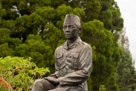 Téléchargez les photos : Une statue de Soekarno, premier président indonésien se tient près d'un arbre près d'un monument commémoratif. - en image libre de droit