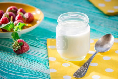 Téléchargez les photos : Pot de yaourt et fraise sur table en bois de couleur turquoise - en image libre de droit