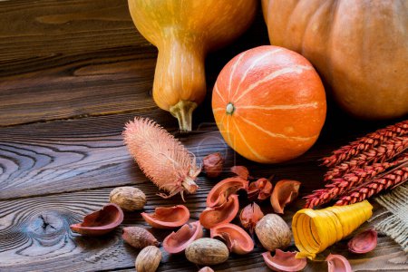 Photo for Pumpkins on wooden background with autumn decorative dry pieces - Royalty Free Image