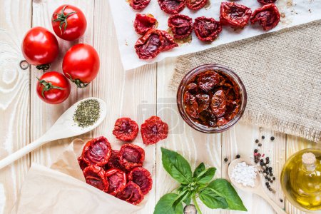 Photo for Dried tomatoes in an envelope of kraft paper on a wooden table covering of sackcloth.  top view - Royalty Free Image