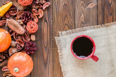 Photo for Red cup of tea on wooden table with sackcloth, autumn decor, pumpkins. top view. copy space - Royalty Free Image