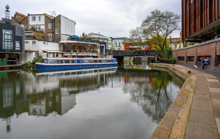 Photo for Camden Town, London, UK: Regents Canal near Camden Market looking towards Camden High Street and Camden Lock. Canal boat, towpath, bridge and bus. - Royalty Free Image
