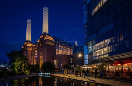 Photo for Battersea, London, UK: Battersea Power Station now redeveloped as a shopping and leisure destination. Night landscape view with pond in foreground. - Royalty Free Image