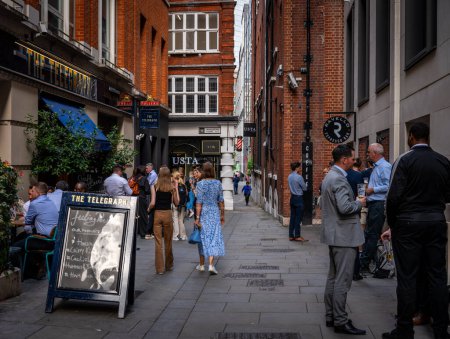 Foto de London, UK: The Telegraph pub in Telegraph Street on the corner of Whalebone Court in the City of London. La gente disfruta de una copa por la noche después del trabajo. - Imagen libre de derechos