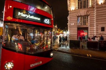 Photo for London, UK - Nov 20 2023: Red London bus with motion blur at the junction of Piccadilly Circus and Regent Street. - Royalty Free Image